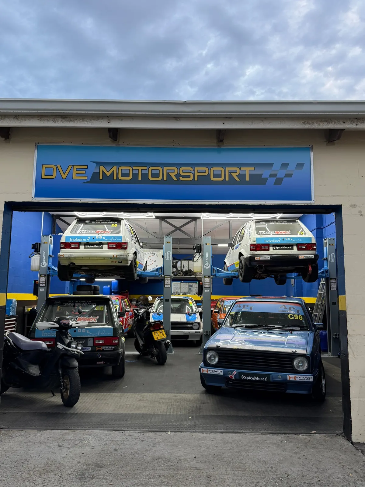 DVE Motorsport workshop in Gasoline Alley with vehicles on the lifts